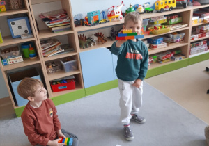 Chłopiec prezentuje swoją budowlę z klocków