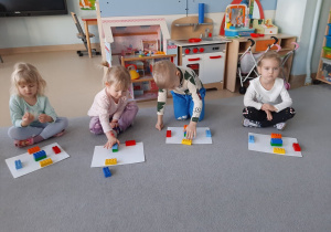 Dzieci układają klocki w odpowiednim miejscu na podkładce