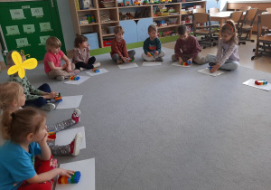 Dzieci układają klocki według słownej instrukcji nauczyciela