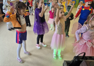 Dzieci tańczą z uniesionymi rękami.