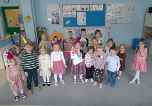 Grupa dzieci pozuje do zdjęcia, dziewczynka trzyma pinatę Jednorożca