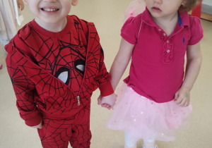 Dziewczynka i chłopiec trzymając się za ręce pozują do zdjęcia