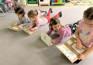 Dziewczynki bawią się papierowymi laptopami