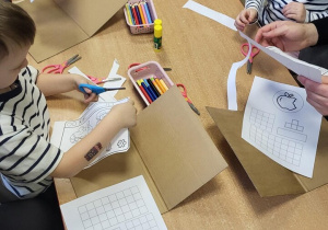 Dzieci wykonują papierowe laptopy