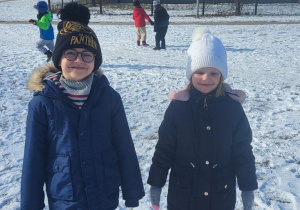 Chłopiec i dziewczynka uśmiechają się do zdjęcia na śniegu