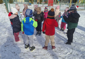 Dzieci bawią się w kole na śniegu