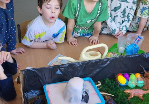 Dzieci oglądają wybuchający wulkan przygotowany przez nauczyciela