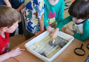 Dzieci rozłupują skamielinę dinozaurów