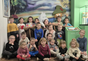 Całą grupa pozuje do zdjęcia na tle Mumunków