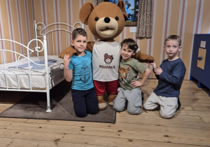 Trzech chłopców pozuje do zdjęcia z Misiem Uszatkiem