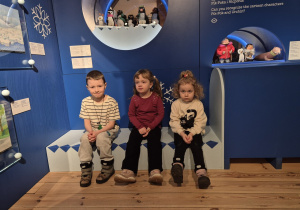 Chłopiec i dwie dziewczynki siedzą na ławce