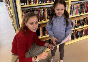 Dziewczynka rozmawia z panią bibliotekarką.