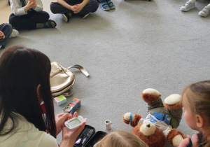 Dzieci obserwują jak prowadząca mierzy sobie poziom cukru we krwi