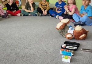 Dzieci siedzą w kole podczas warsztatów dotyczących cukrzycy