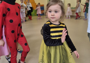 Na pierwszym planie dziewczynka w stroju pszczoły i chłopiec w stroju biedronki.