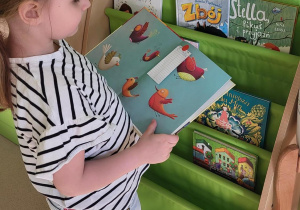 Dziewczynka trzyma książkę w ręku