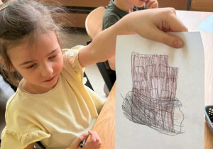 Dziewczynka pokazuje pracę