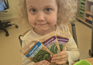 Dziewczynka pokazuje rodzaje nasion.