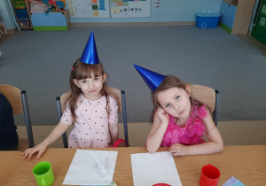 Dwie dziewczynki siedzą przy stole