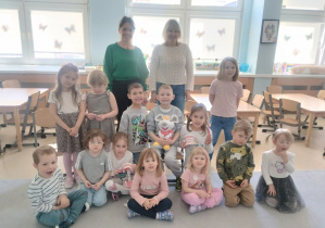 Dzieci z grupy niebieskiej pozują na dywanie z paniami prowadzącymi warsztaty