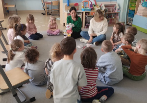 Dzieci z grupy niebieskiej słuchają pań opowiadających o sposobach dbania o zdrowe zęby