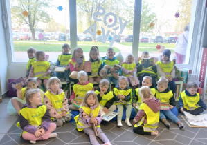 Dzieci siedzą w bibliotece z wybraną książką
