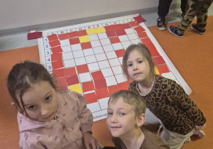 Dzieci pozują z obrazkiem godła