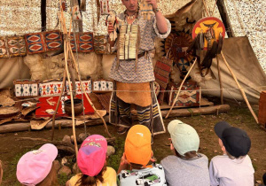 Dzieci siedzą w tipi i słuchają opowieści o zwyczajach Indian.