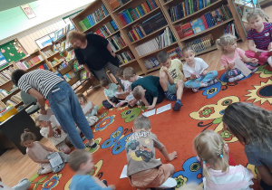 Dzieci oglądają kolorowanki otrzymane od Pani Bibliotekarki