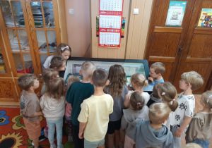 Dzieci oglądają w gablocie miniksiążeczki