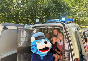 Dzieci siedzą w radiowozie