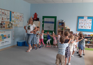 Nauczycielka wraz z dziećmi tańczy do piosenki