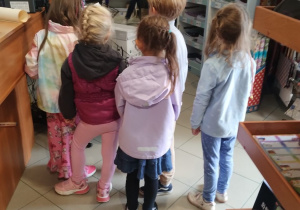 Dzieci wybierają w sklepie papierniczym kartony i papier kolorowy do prac plastycznych